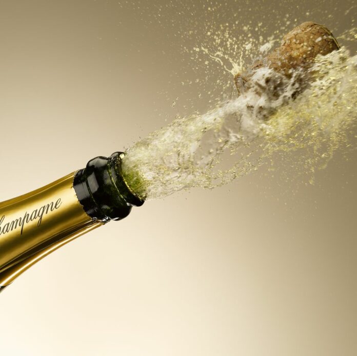 champagne-and-cork-exploding-from-bottle-royalty-free-image-1654271963